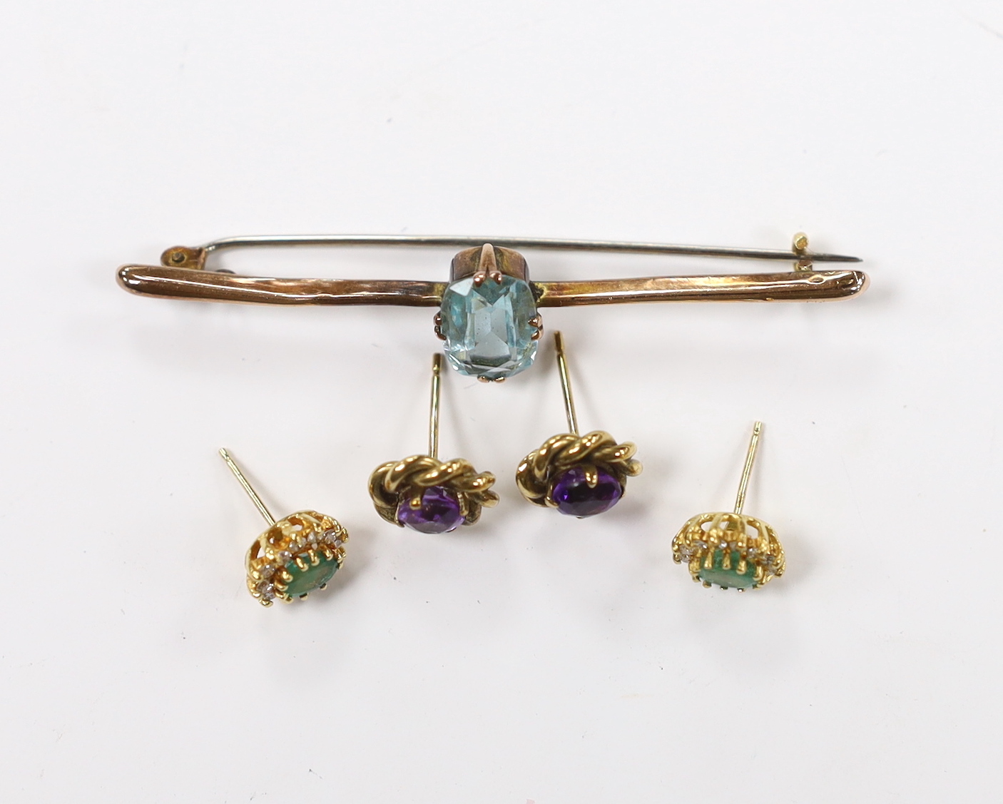 A pair of 18ct gold, emerald and diamond set oval cluster ear studs, one other pair of ear studs (both pairs lacking butterflies) and a 9ct and gem set bar brooch. Fair condition.